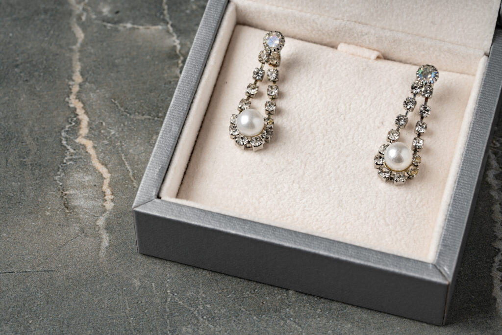 Pendientes dorados y joyero sobre la mesa – foto en primer plano.